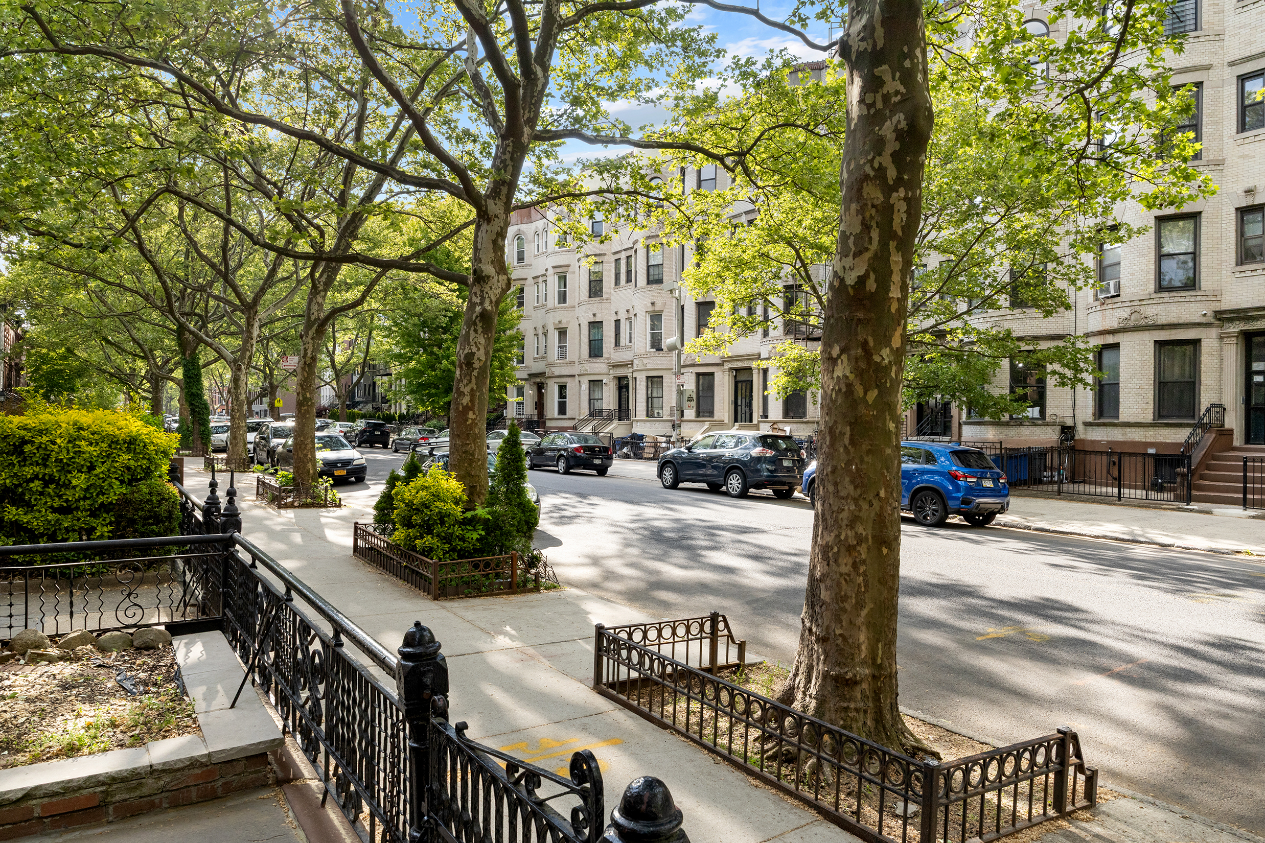 306 Halsey Street Brooklyn, NY 11216 - Photo 10 of 10 a street view with tall buildings and cars parked on road