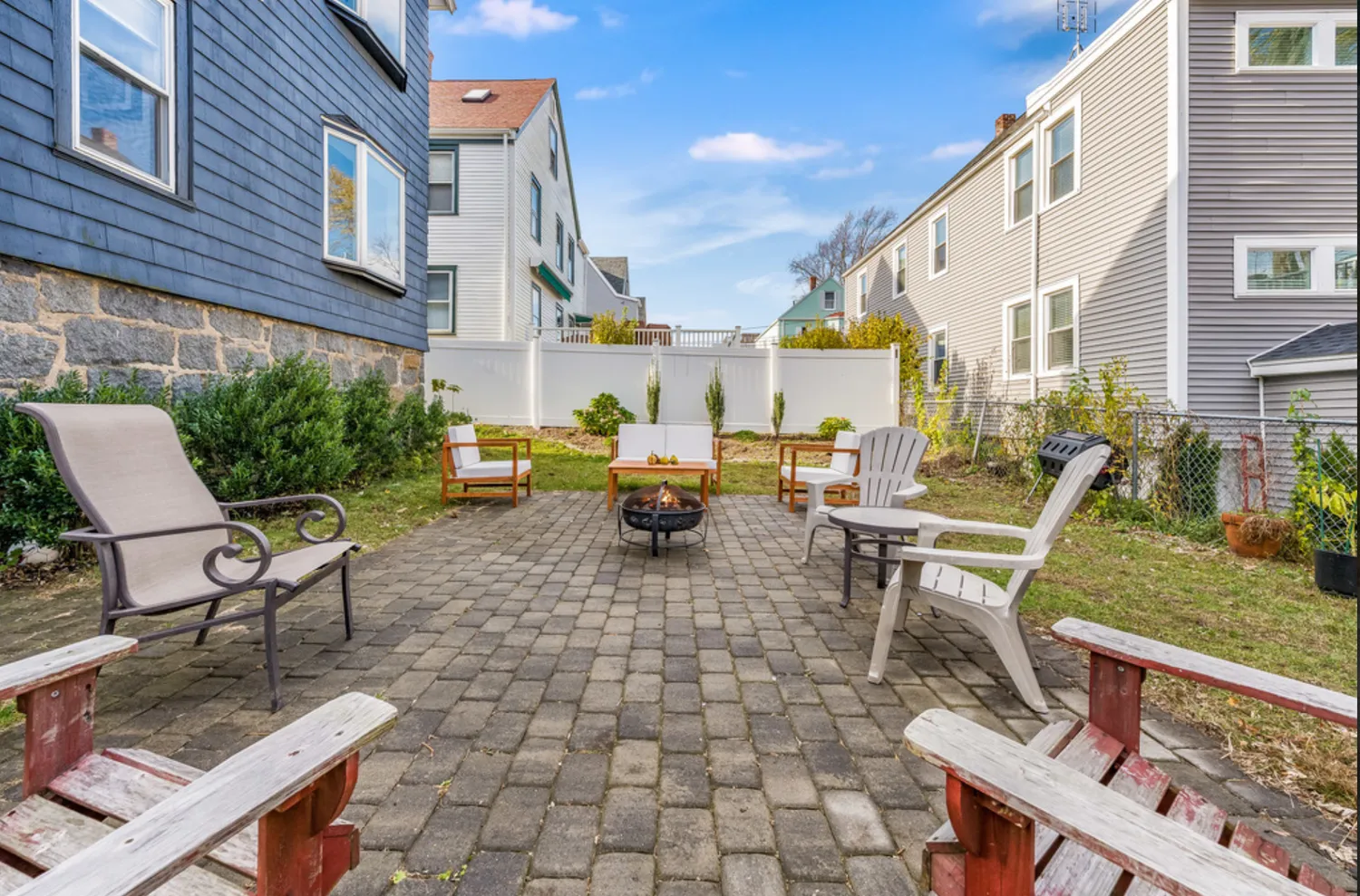 a view of a patio with table and chairs and a barbeque