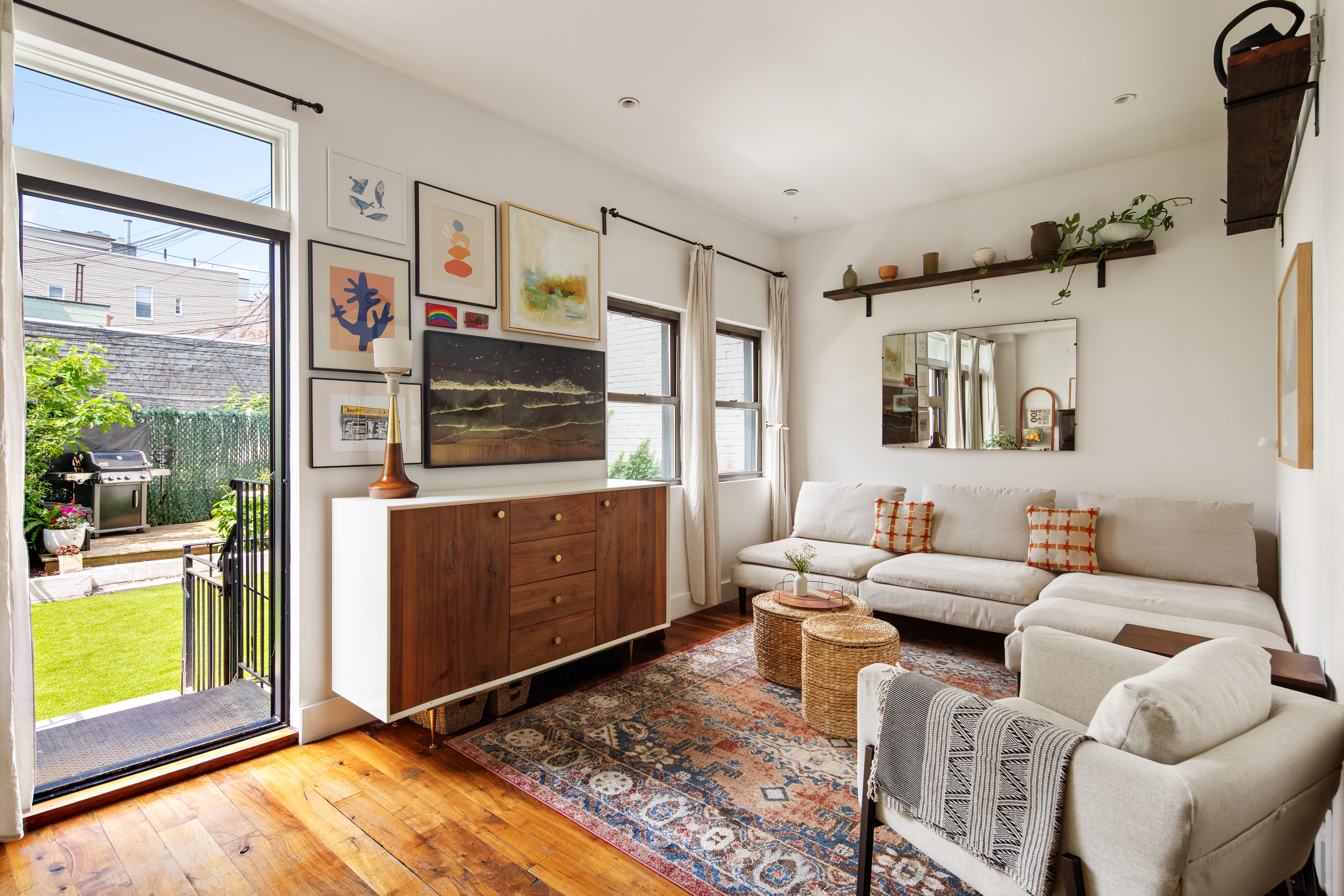 a living room with furniture a flat screen tv and a floor to ceiling window