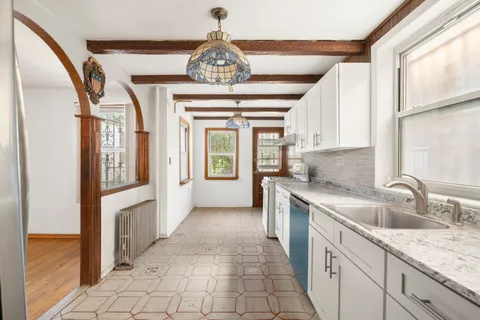 a view of a kitchen with granite countertop a sink and dishwasher with a large window
