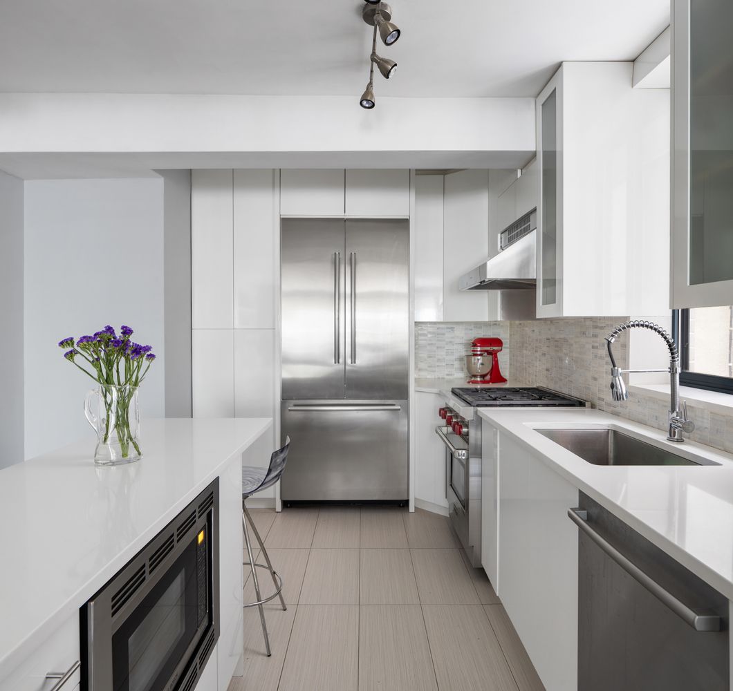 167 Perry Street, Unit 2F Manhattan, NY 10014 - Photo 2 of 11 a kitchen with stainless steel appliances granite countertop a sink a stove and a refrigerator