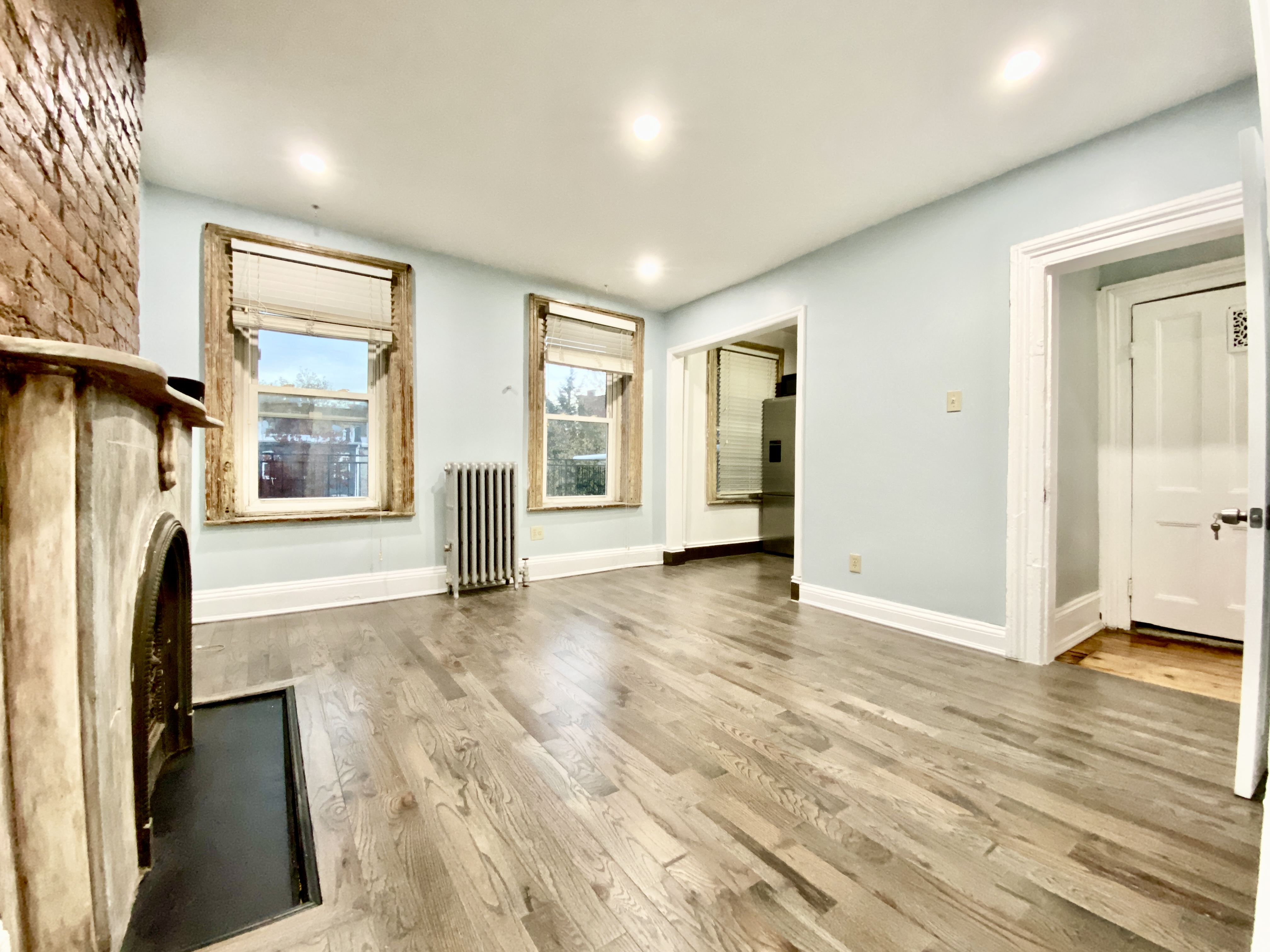 398 Decatur Street, Unit 3 Brooklyn, NY 11233 - Photo 1 of 9 wooden floor in an empty room with a fireplace