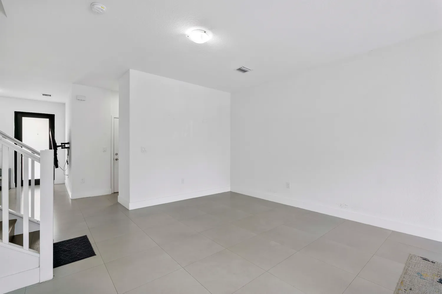 an empty room with wooden floor and staircase
