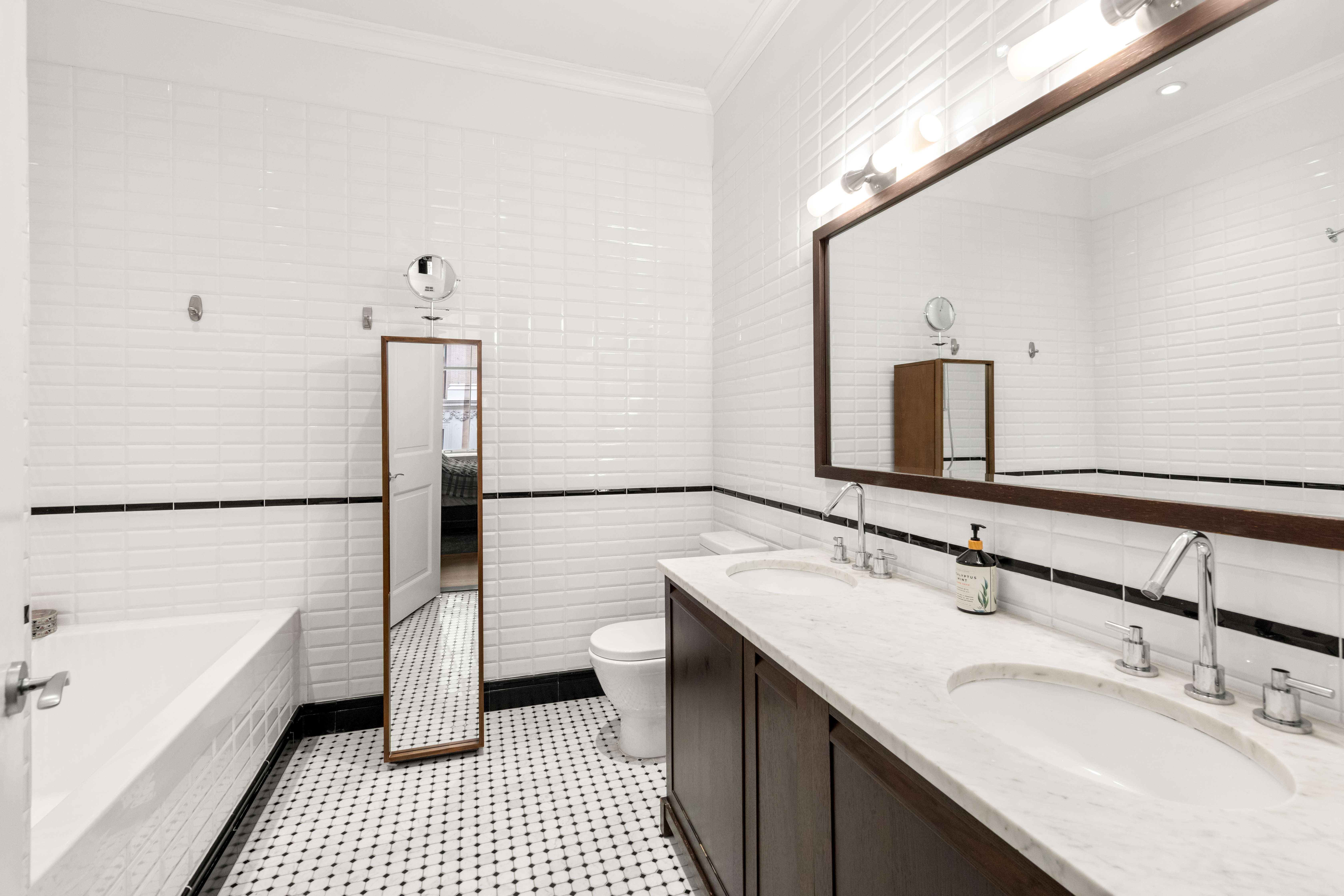 655 6th Avenue, Unit 5H Manhattan, NY 10010 - Photo 8 of 15 a bathroom with a sink double vanity and a bathtub