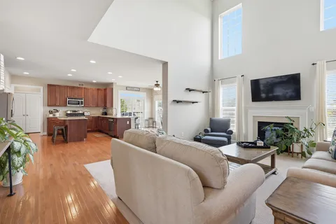 a kitchen with stainless steel appliances kitchen island granite countertop wooden floors and wooden cabinets