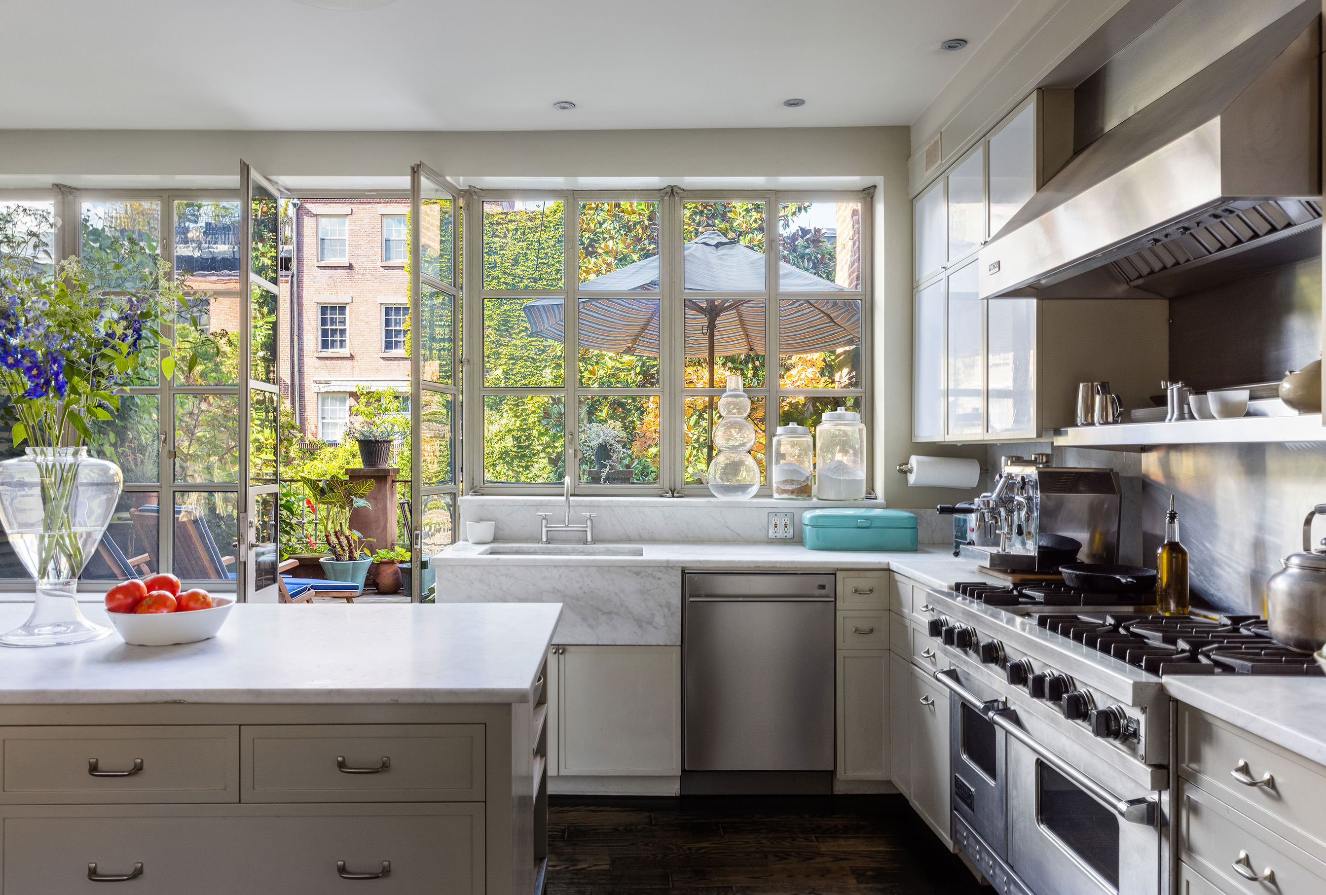 25 Perry Street Manhattan, NY 10014 - Photo 17 of 32 a kitchen with kitchen island a stove a sink and a large window