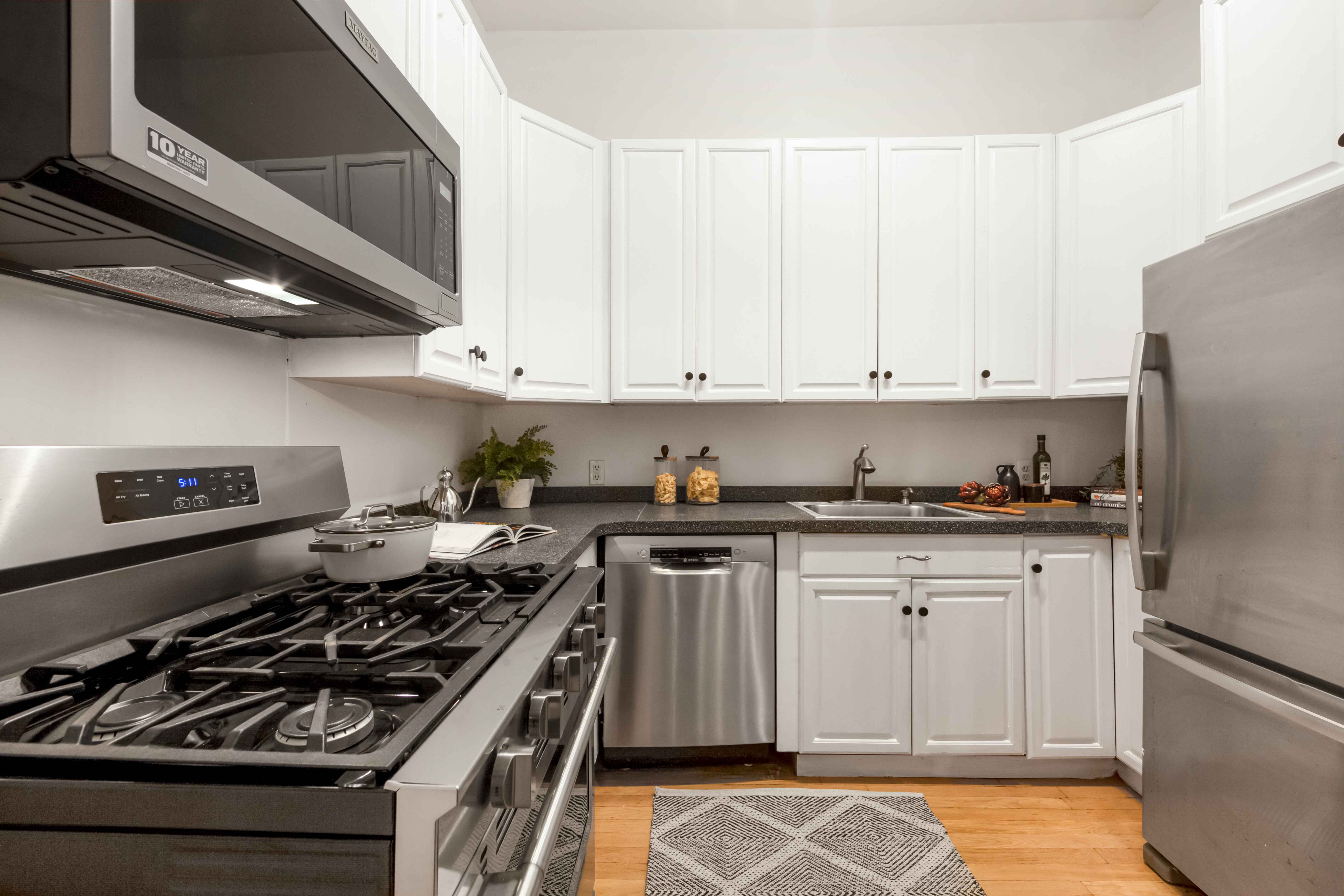 420 6th Avenue, Unit 11 Brooklyn, NY 11215 - Photo 3 of 10 a kitchen with stainless steel appliances granite countertop a stove a sink dishwasher and refrigerator with wooden floor