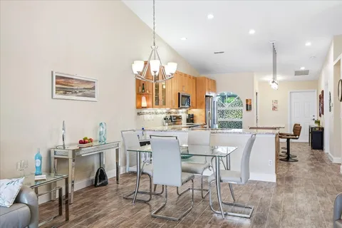 a dining room with a table chairs and a kitchen view