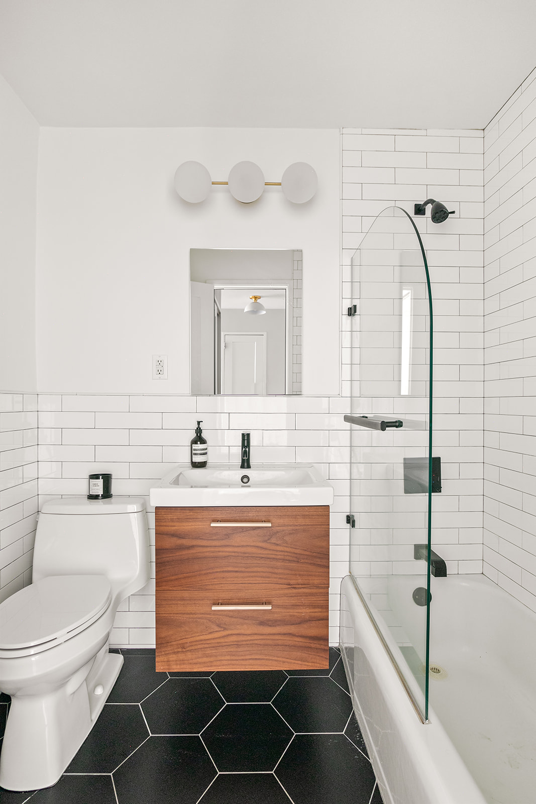 333 East 79th Street, Unit 1R Manhattan, NY 10075 - Photo 7 of 12 a bathroom with a granite countertop sink toilet a mirror and bathtub