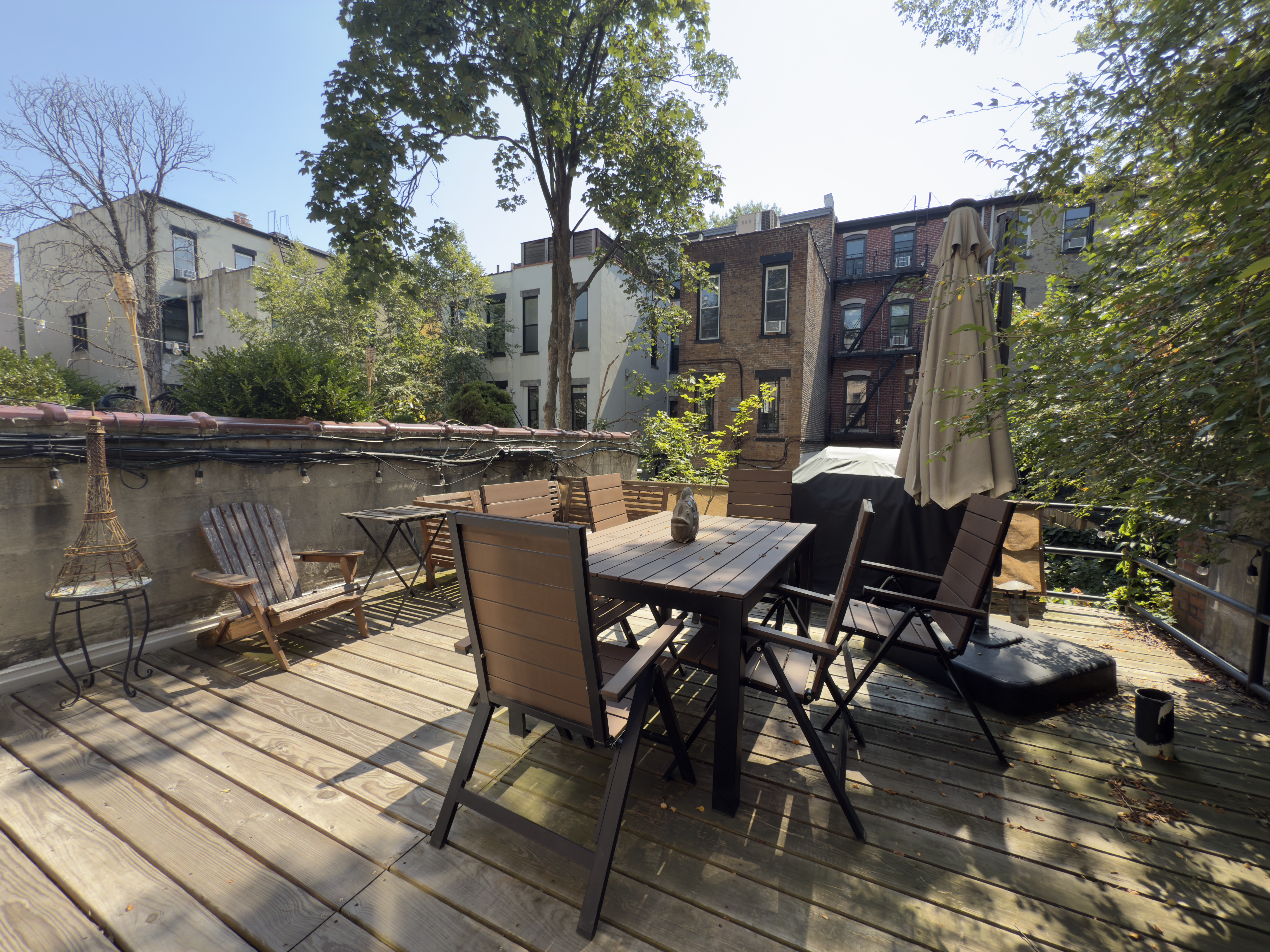 a view of a roof deck with table and chairs and wooden floor
