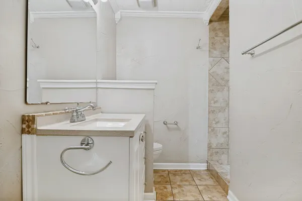 a bathroom with a granite countertop sink a toilet and shower