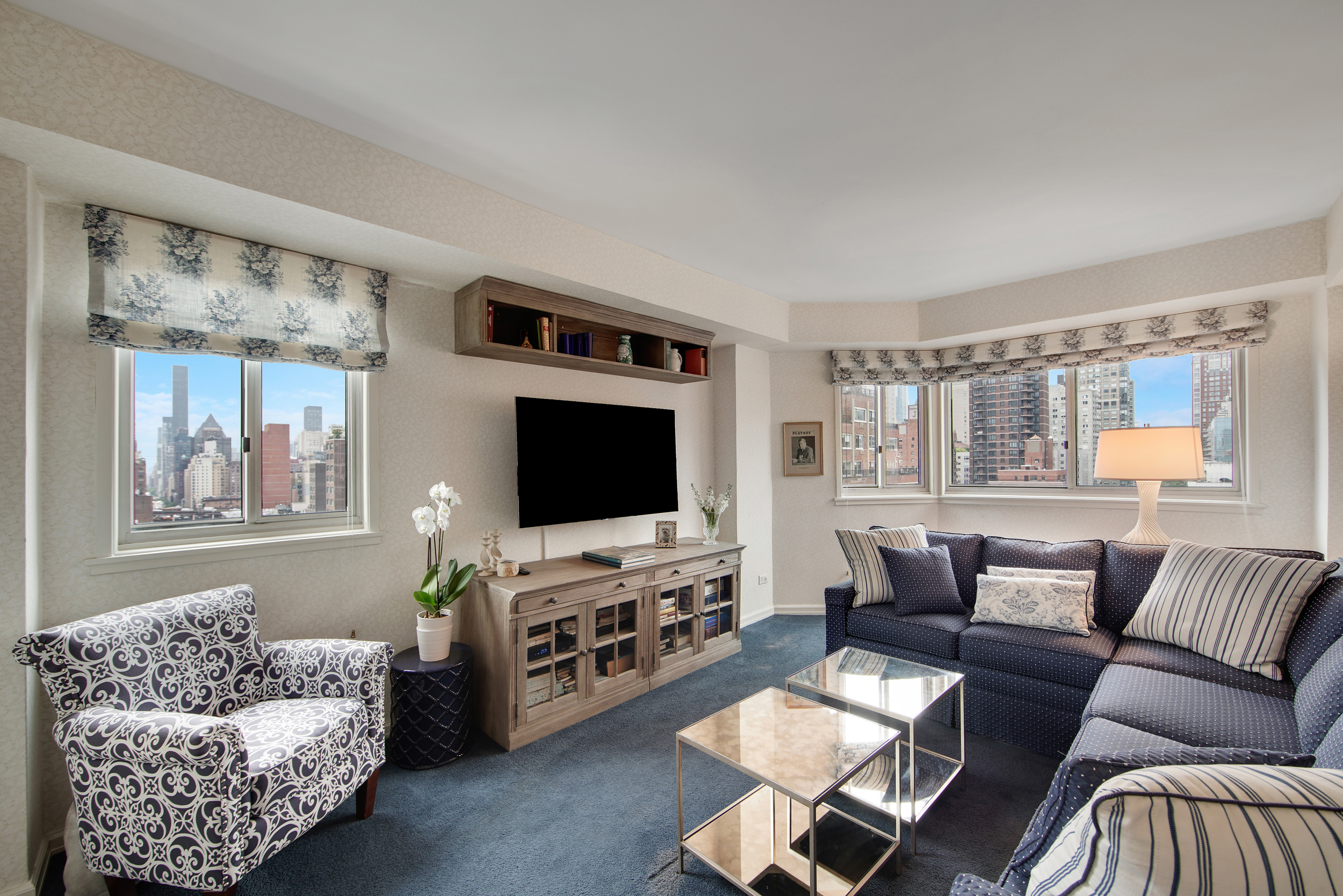 401 East 65th Street, Unit 16C Manhattan, NY 10065 - Photo 8 of 13 a living room with furniture and a flat screen tv