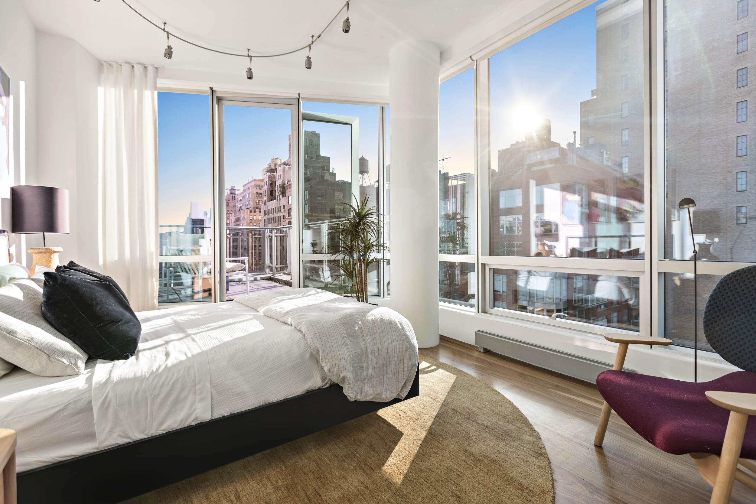 166 West 18th Street, Unit PH11 Manhattan, NY 10011 - Photo 9 of 16 a bedroom with a bed and glass window