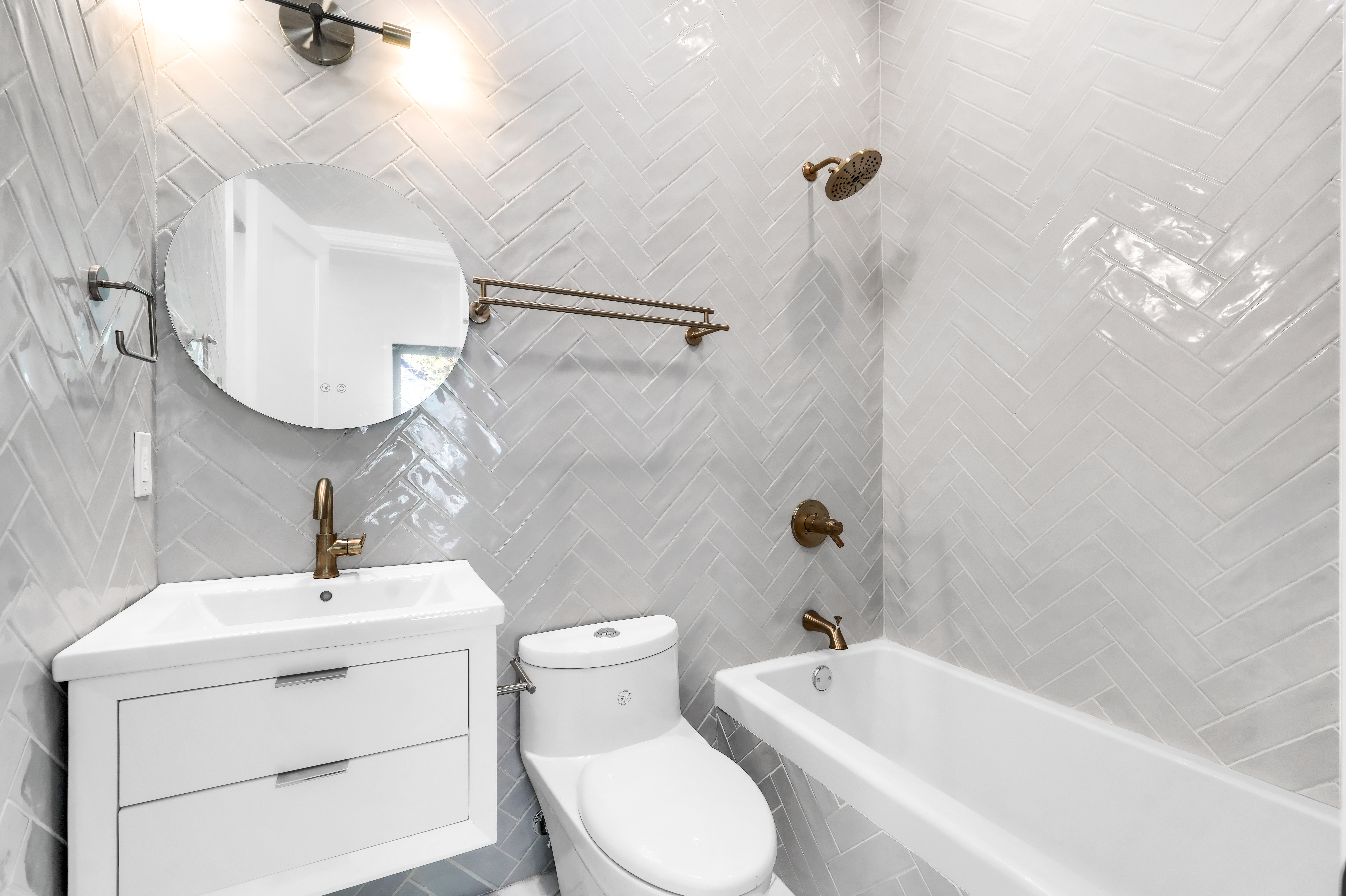 473 Monroe Street Brooklyn, NY 11221 - Photo 20 of 40 a bathroom with a toilet a sink a mirror and bathtub