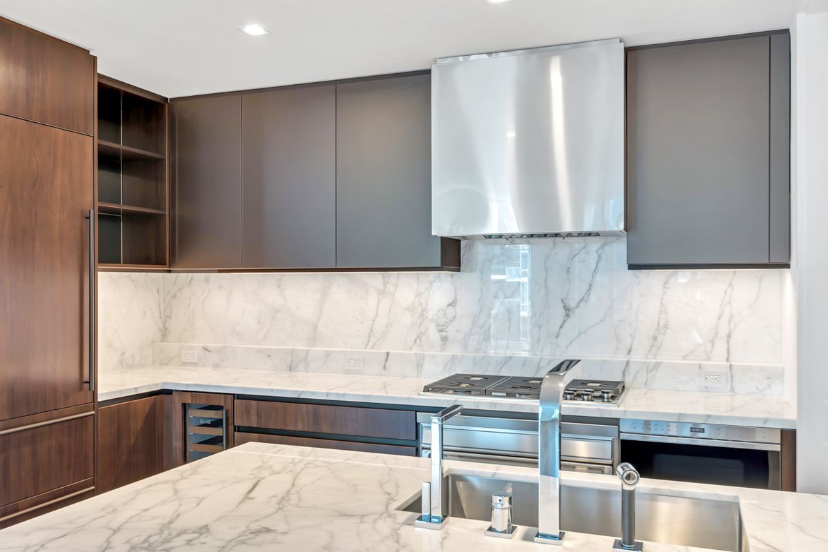 1 West End Avenue, Unit 27D Manhattan, NY 10023 - Photo 5 of 21 a kitchen with granite countertop a stove a sink and a refrigerator