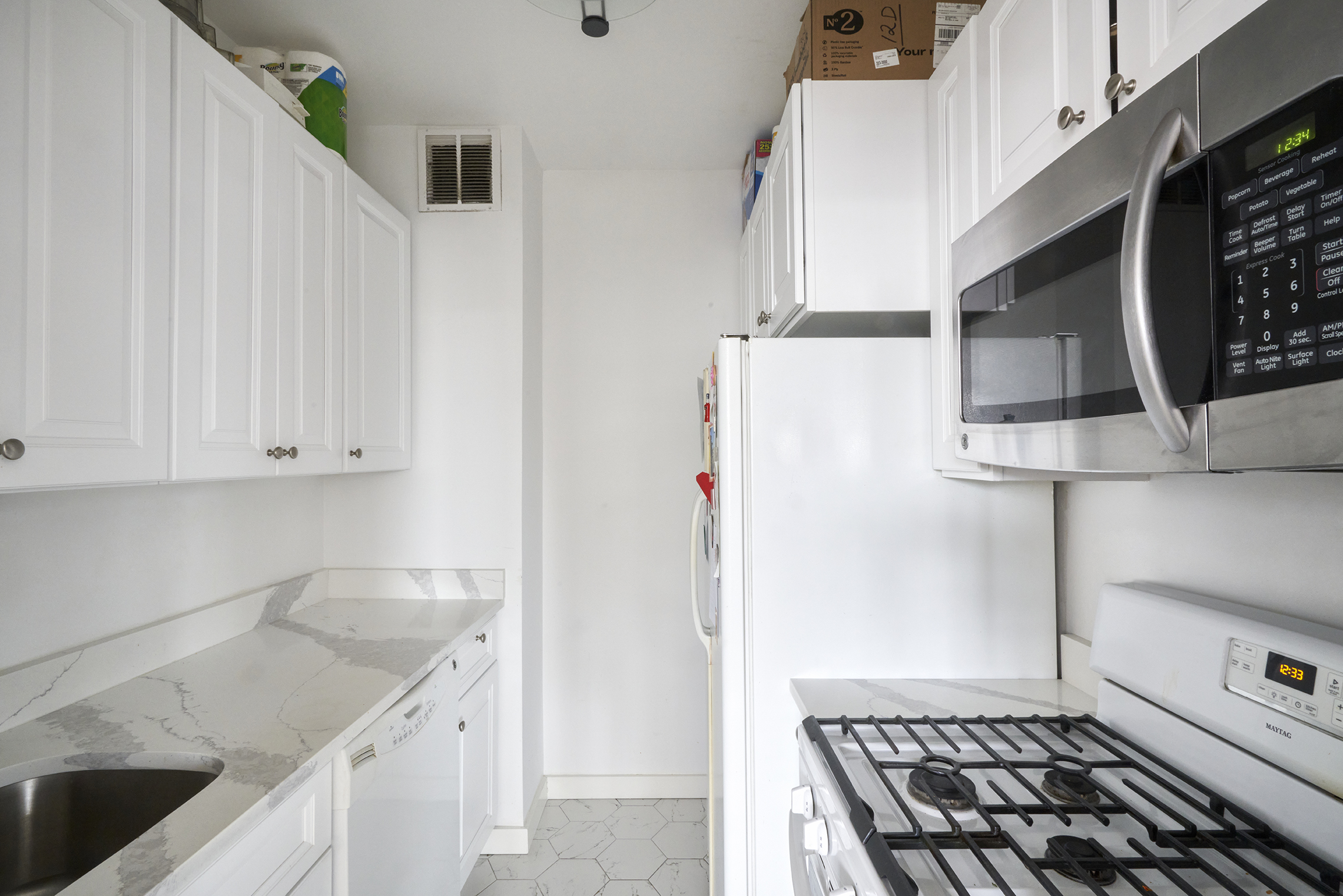 304 East 65th Street, Unit 12D Manhattan, NY 10065 - Photo 2 of 6 a kitchen with stainless steel appliances granite countertop a refrigerator and a stove