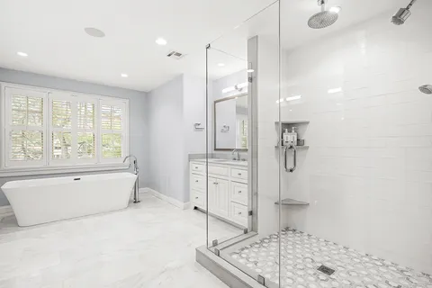 a spacious bathroom with a tub sink and shower