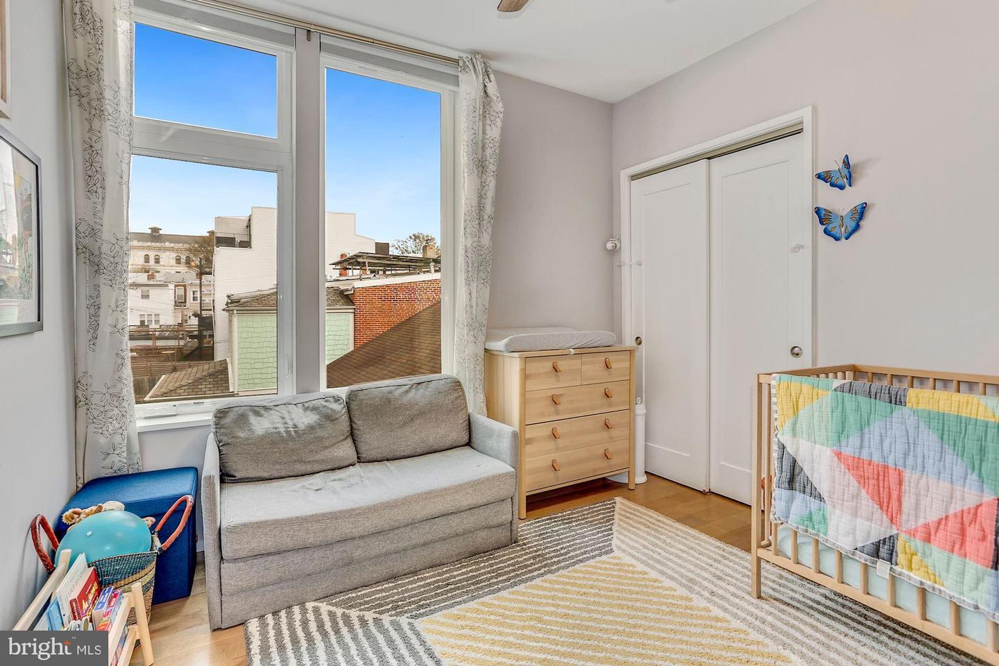 129 Varnum Street Northwest, Unit 6 Washington, DC 20011 - Photo 20 of 25 a living room with furniture and a baby crib