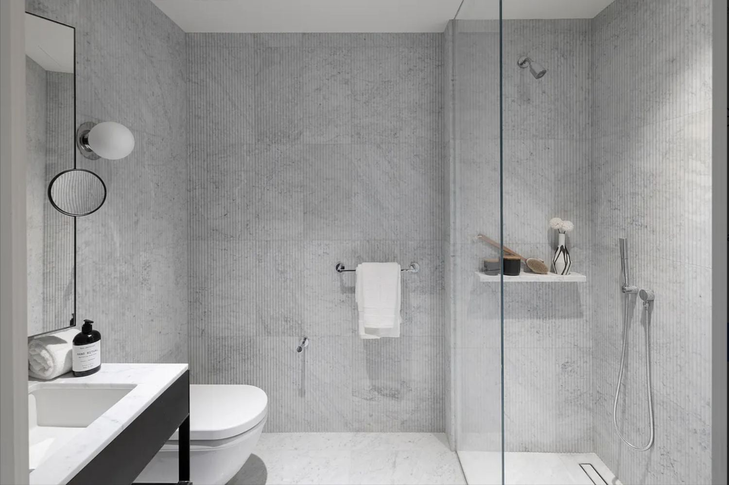 135 East 47th Street, Unit 12C Manhattan, NY 10017 - Photo 6 of 15 a bathroom with a sink toilet and shower