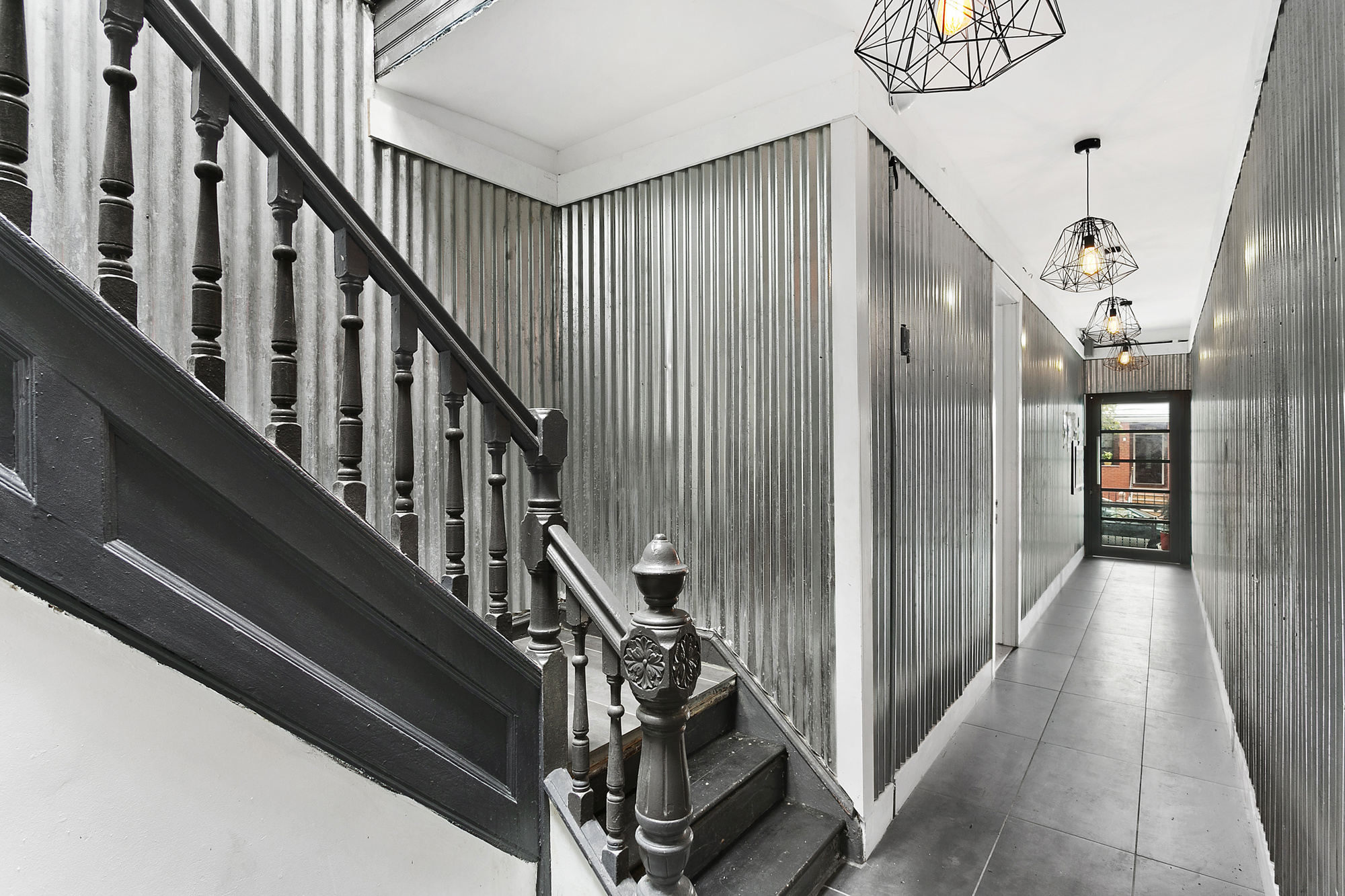 342 East 9th Street Brooklyn, NY 11218 - Photo 4 of 12 a view of staircase with lots of frames on wall and wooden floor