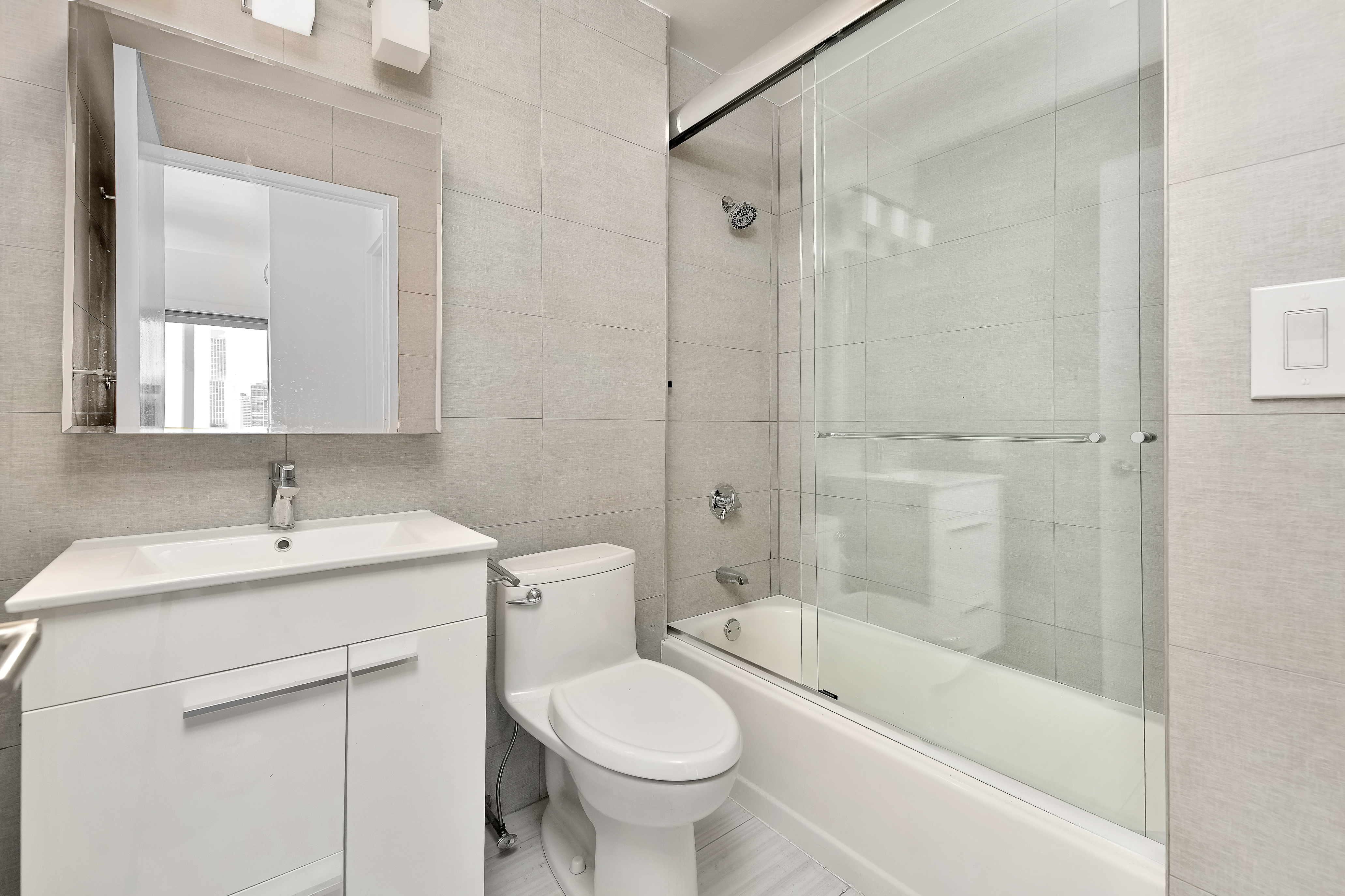415 East 37th Street, Unit 32G Manhattan, NY 10016 - Photo 7 of 19 a bathroom with a sink toilet and shower
