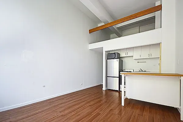 a kitchen with stainless steel appliances a refrigerator and wooden floor