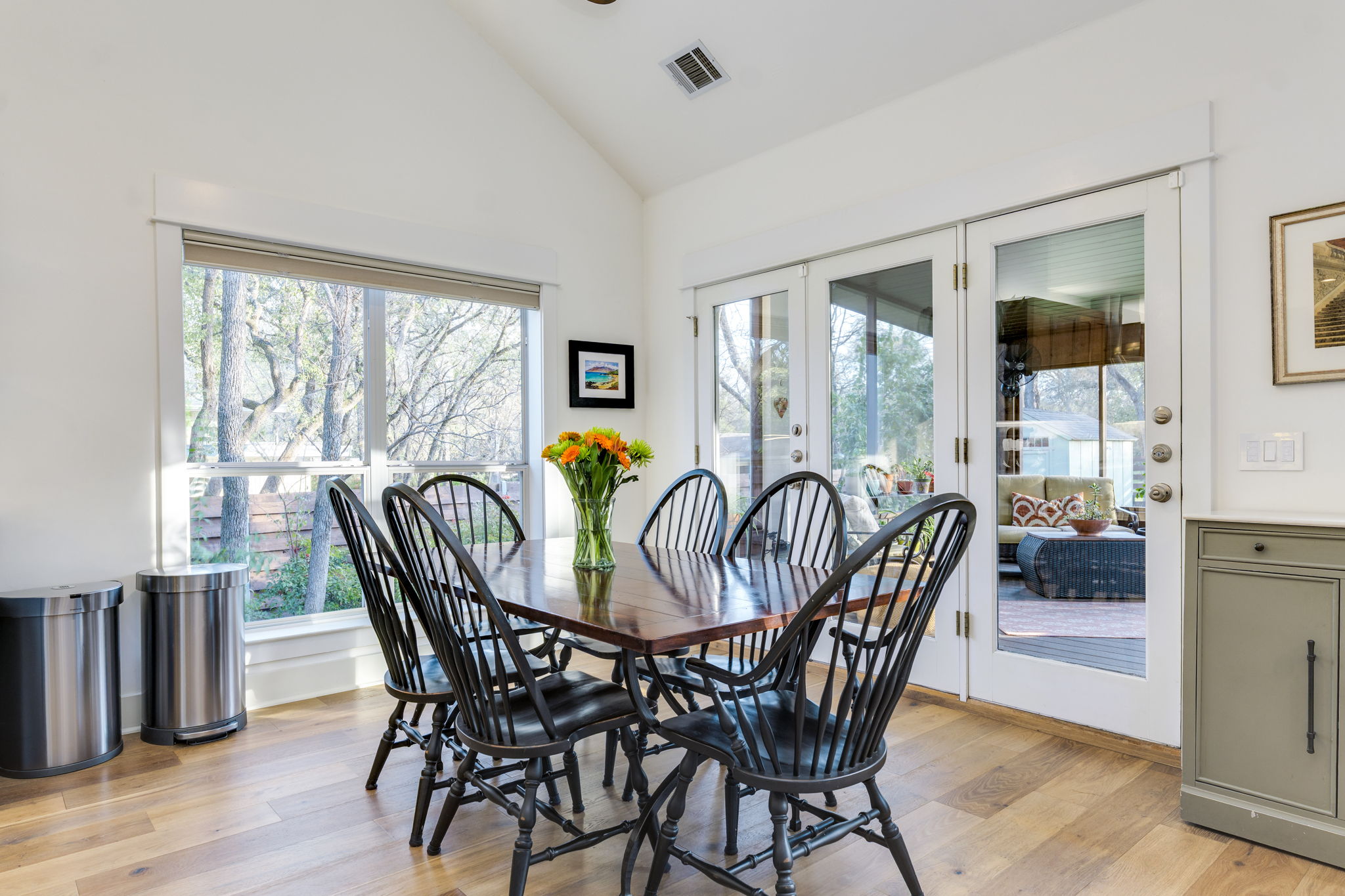 109 West Spring Drive Austin, TX 78746 - Photo 12 of 22 a dining room with furniture a chandelier and wooden floor