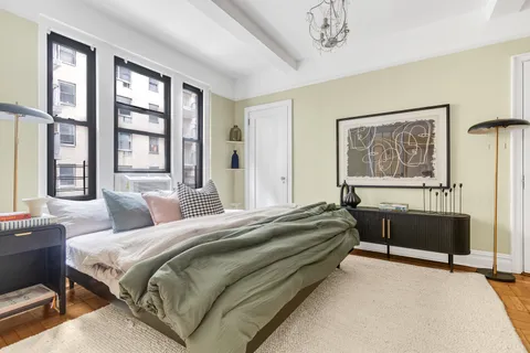 a spacious bedroom with a bed and a large window