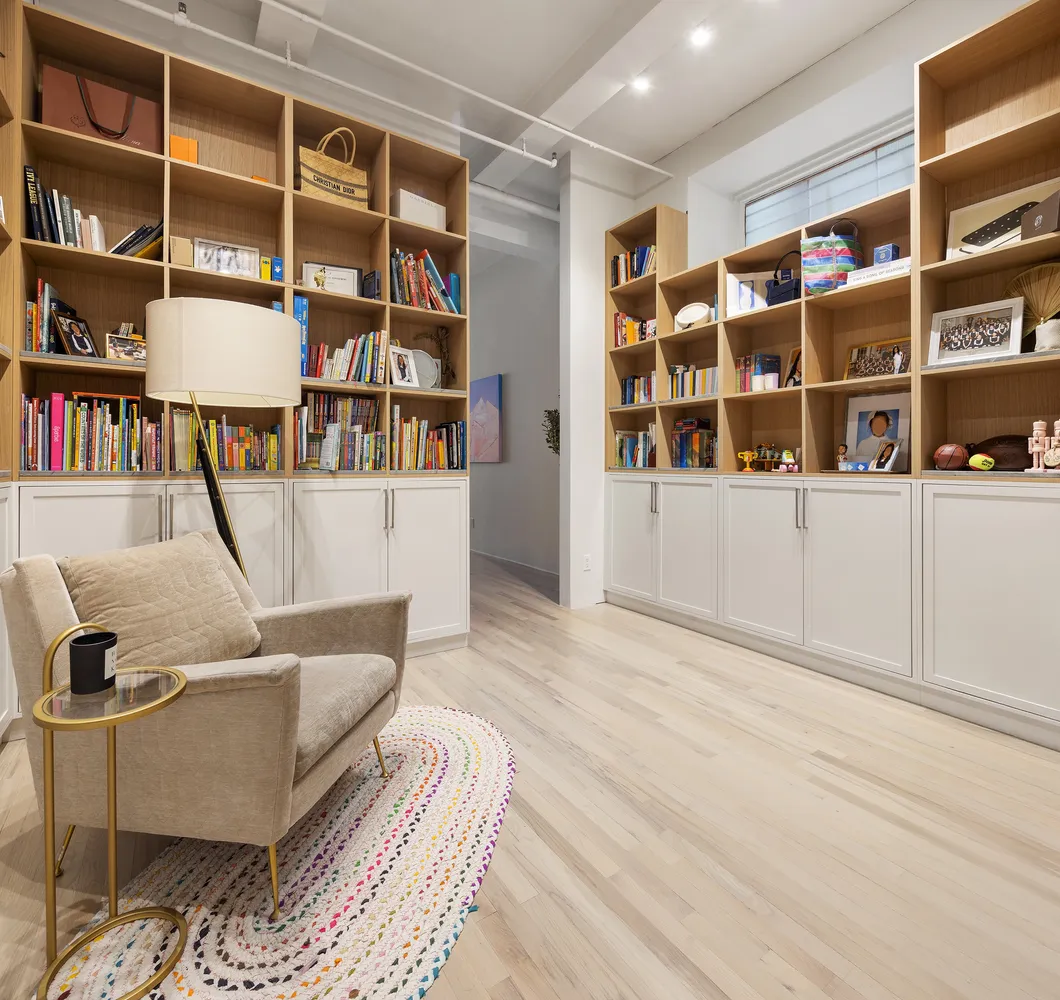 a living room with furniture and a book shelf