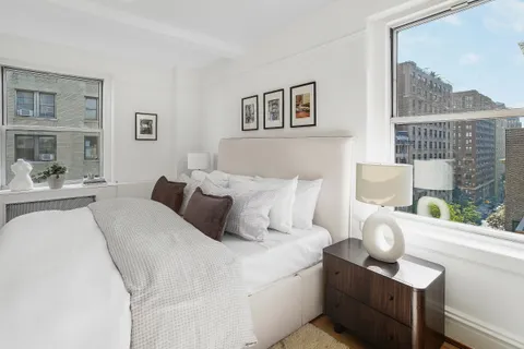 a bedroom with bed and a painting on the wall