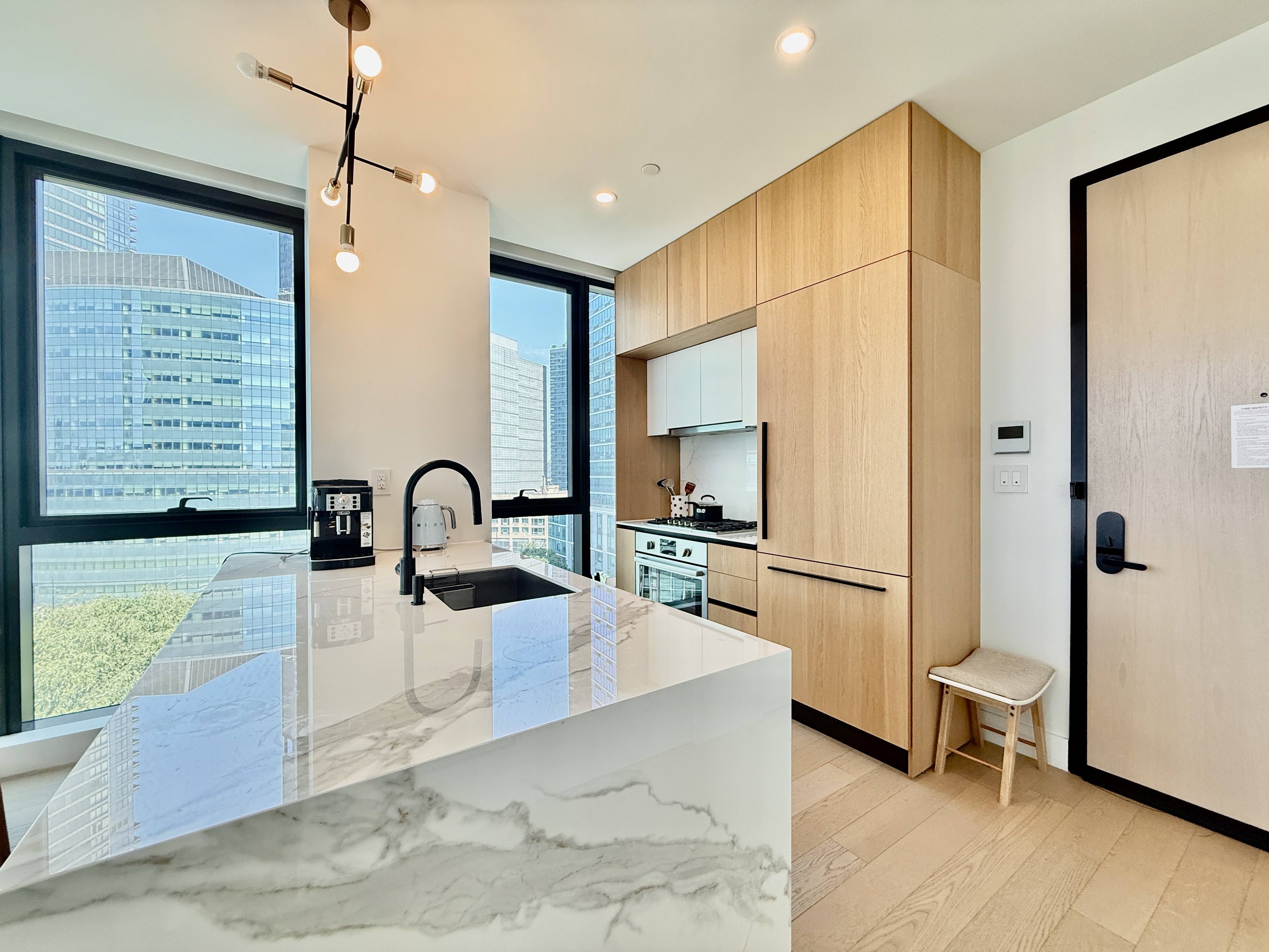 4507 Court Square, Unit 8D Queens, NY 11101 - Photo 5 of 28 a kitchen with kitchen island a counter top space appliances and a counter space