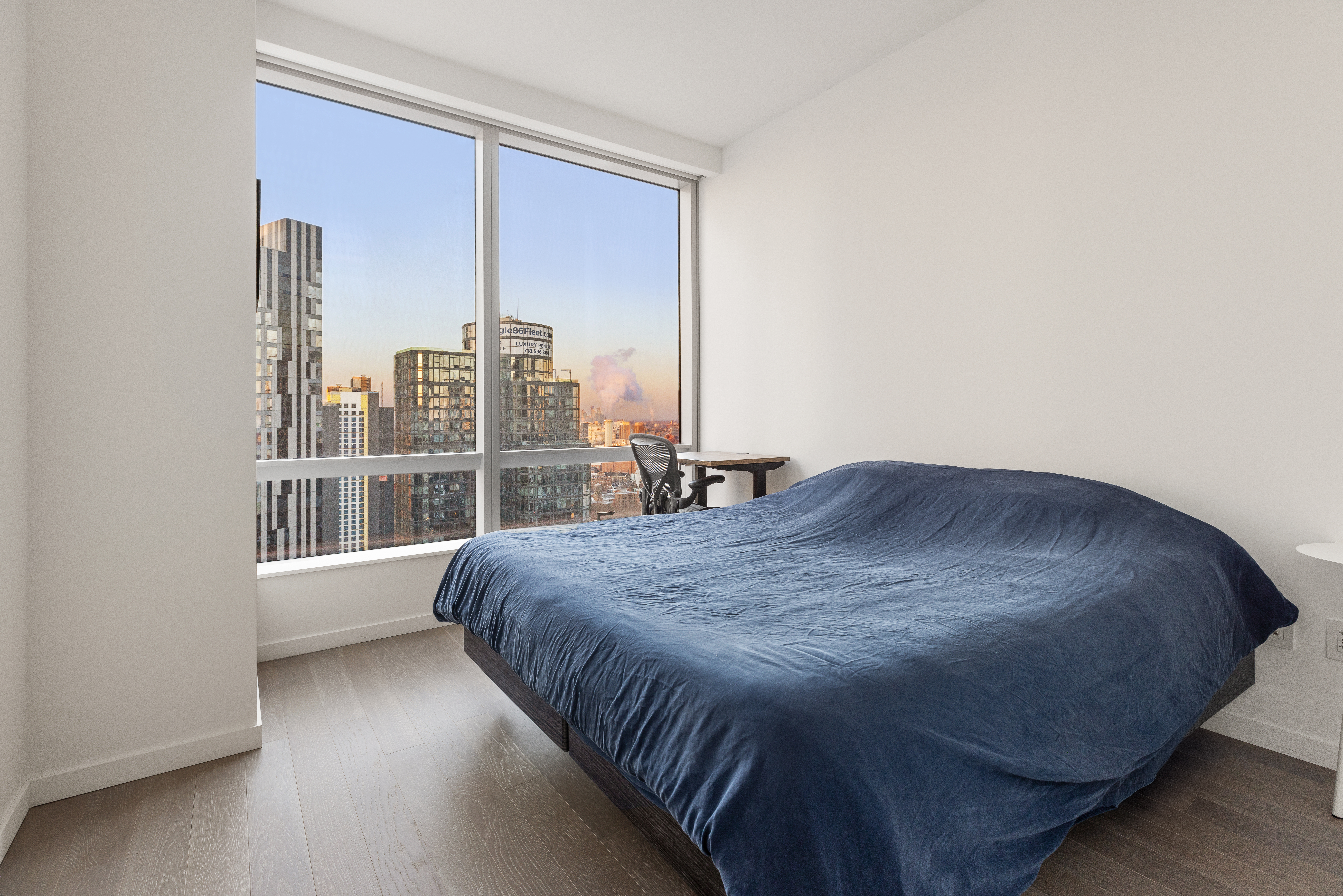 1 City Point, Unit 30D Brooklyn, NY 11201 - Photo 3 of 11 a large bed sitting in a bedroom next to a window