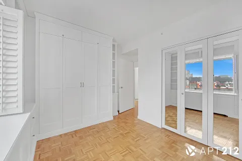 a view of a bedroom with wooden floor