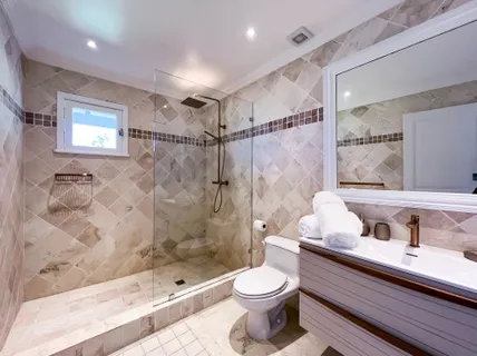 a bathroom with a sink a toilet and shower