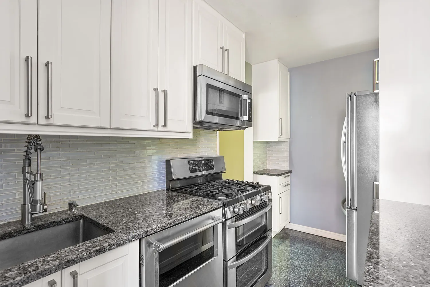a kitchen with stainless steel appliances granite countertop a sink stove and refrigerator