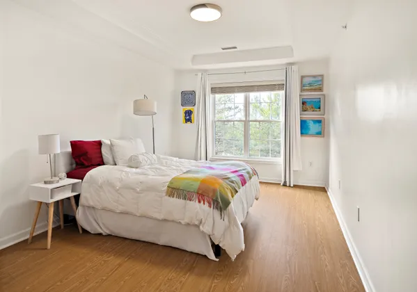 a spacious bedroom with a bed and wooden floor