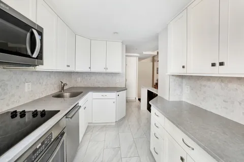 a kitchen with a sink stove and cabinets