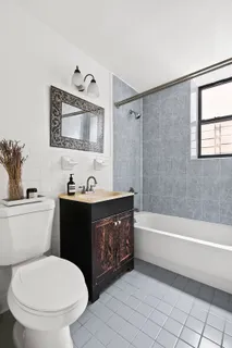 a bathroom with a toilet a sink a mirror and bathtub