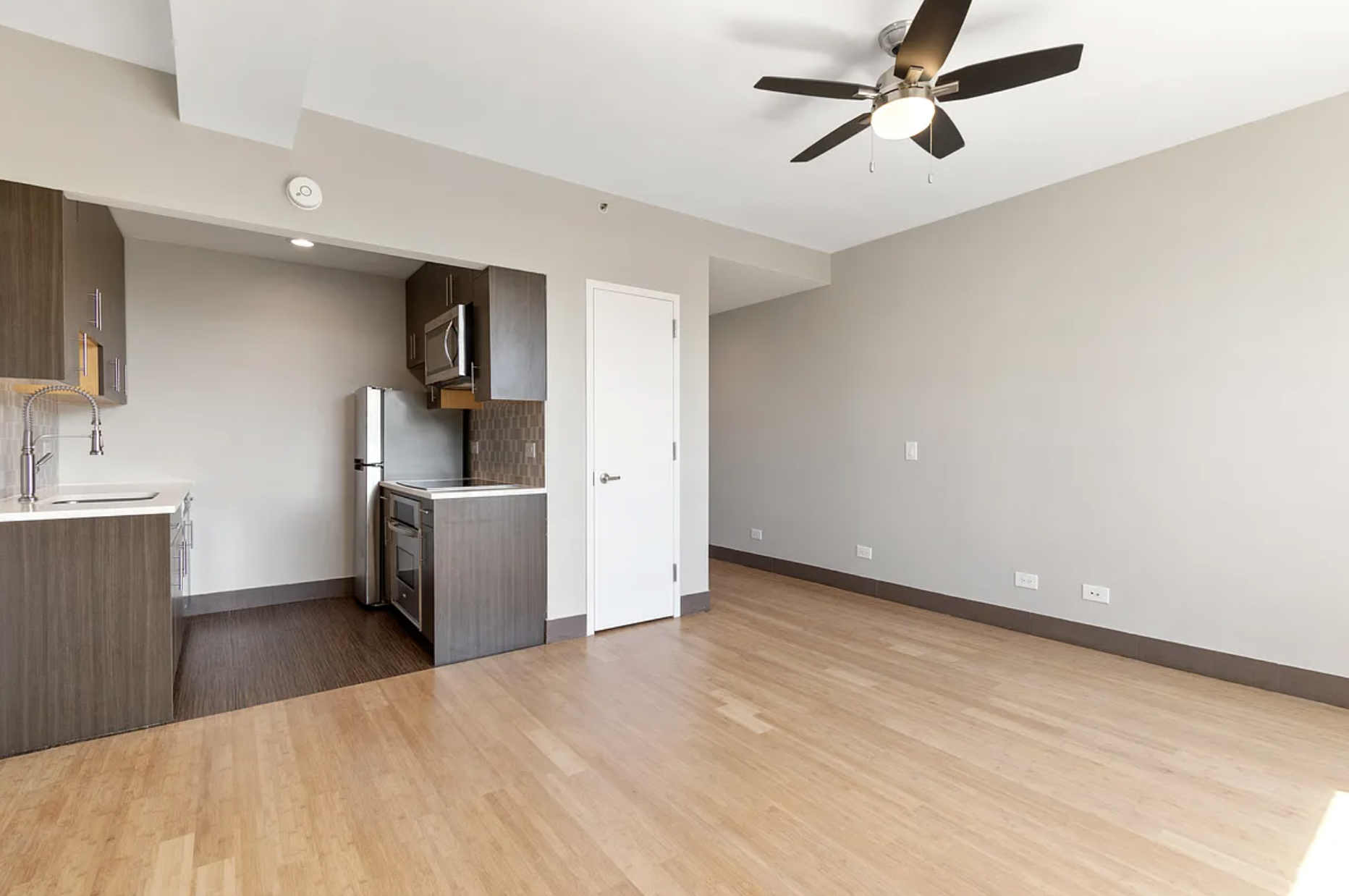5-43 48th Avenue, Unit 5E Queens, NY 11101 - Photo 4 of 9 a view of a kitchen with a sink and a refrigerator