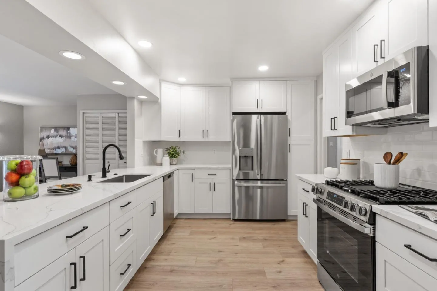 a kitchen with white cabinets white appliances and sink