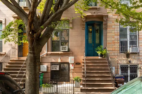 a front view of a house with a tree