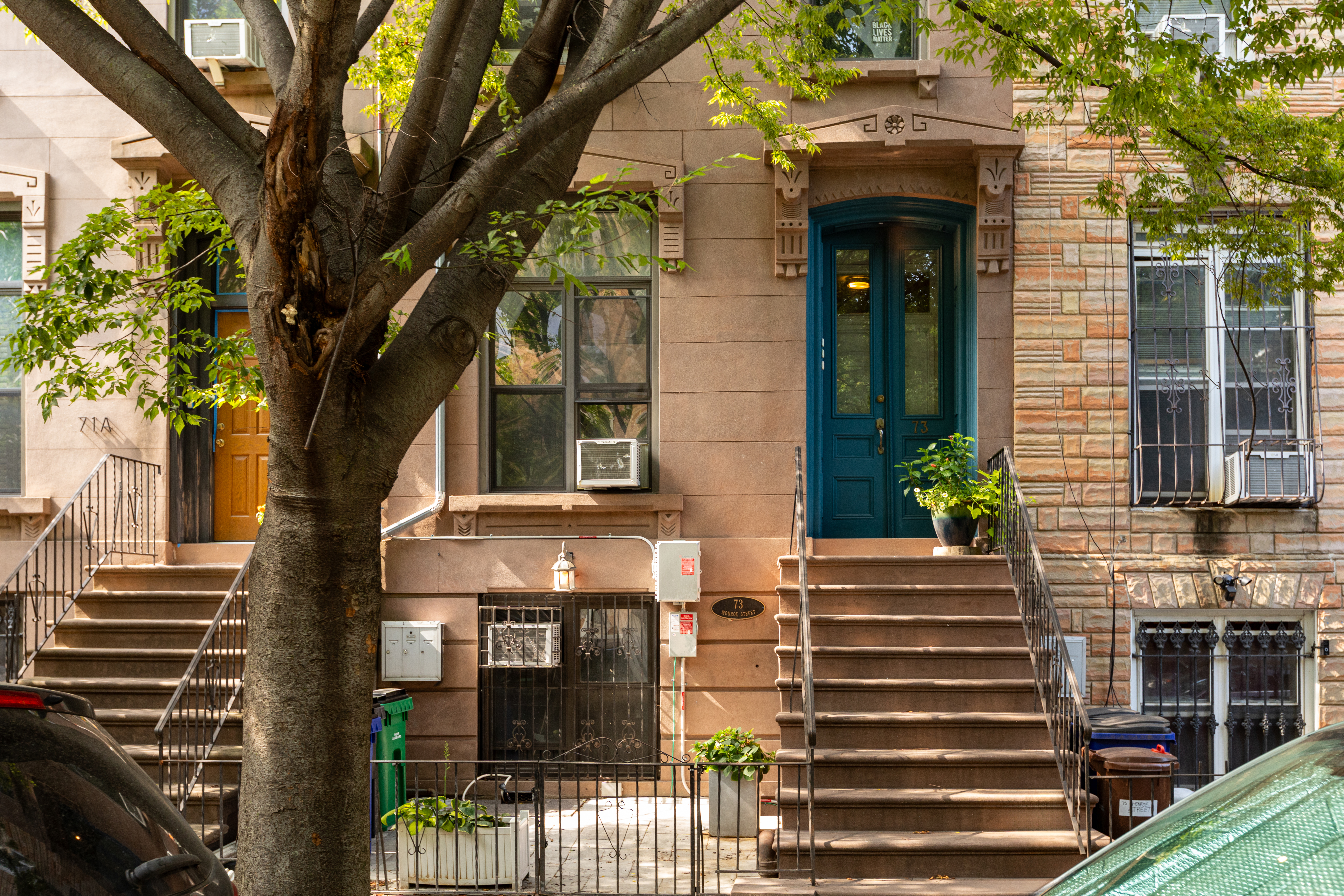 a front view of a house with a tree