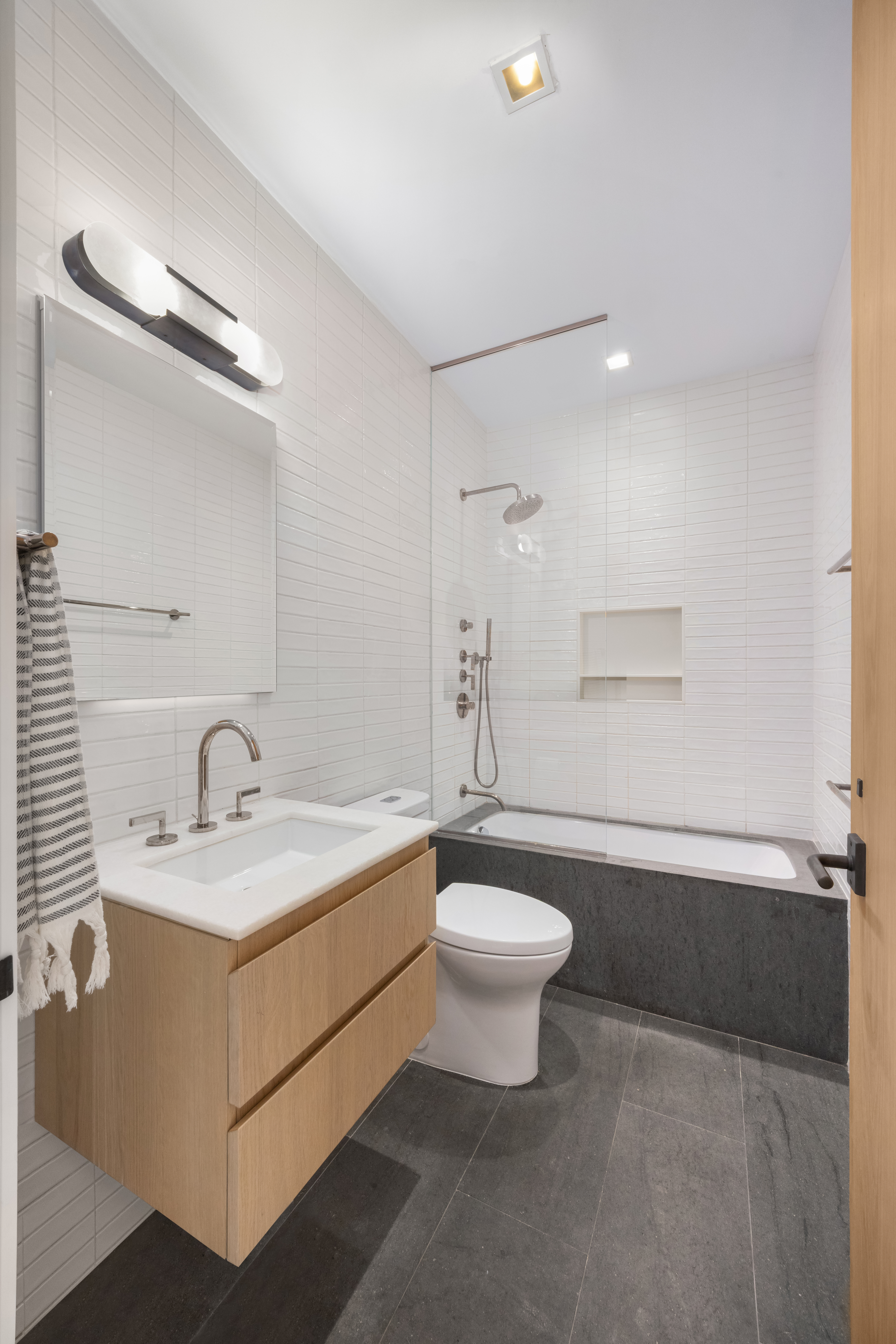 138 North 10th Street, Unit 302 Brooklyn, NY 11249 - Photo 11 of 15 a bathroom with a sink mirror vanity and a bathtub