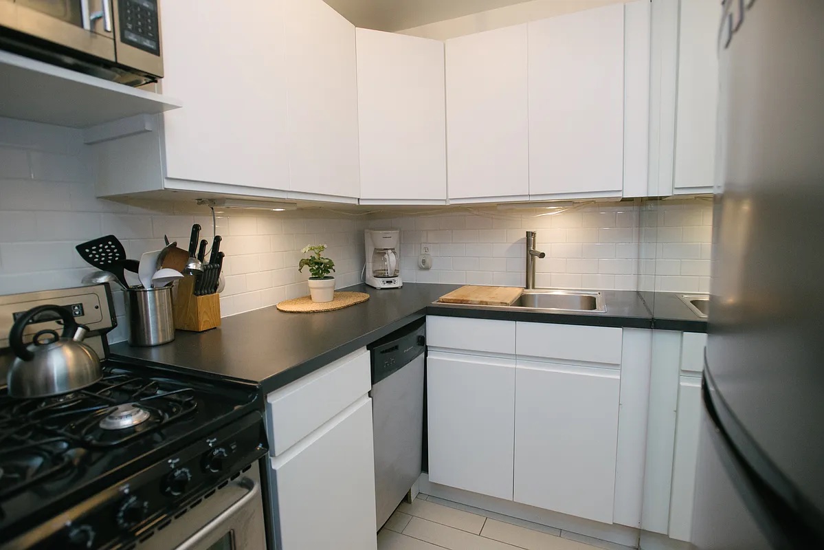 161 West 71st Street, Unit 1A Manhattan, NY 10023 - Photo 4 of 7 a kitchen with white cabinets and appliances