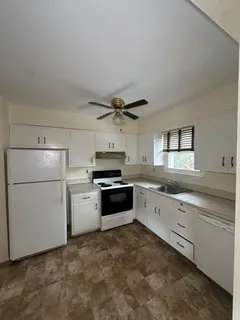 a kitchen with granite countertop a refrigerator and a sink