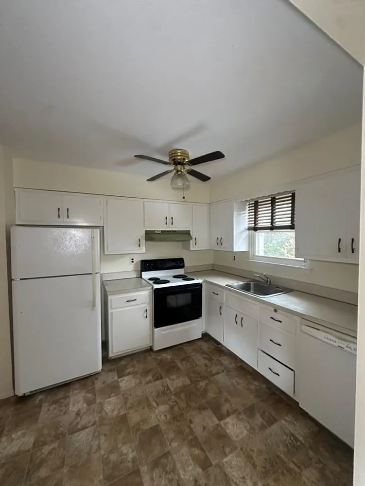 a kitchen with granite countertop a refrigerator and a sink