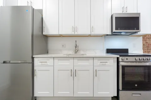 a kitchen with stainless steel appliances white cabinets and a sink