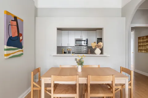a view of kitchen with wooden floor dining table and chairs