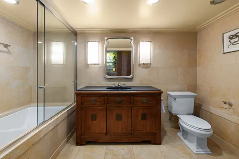 a bathroom with a toilet a sink and mirror