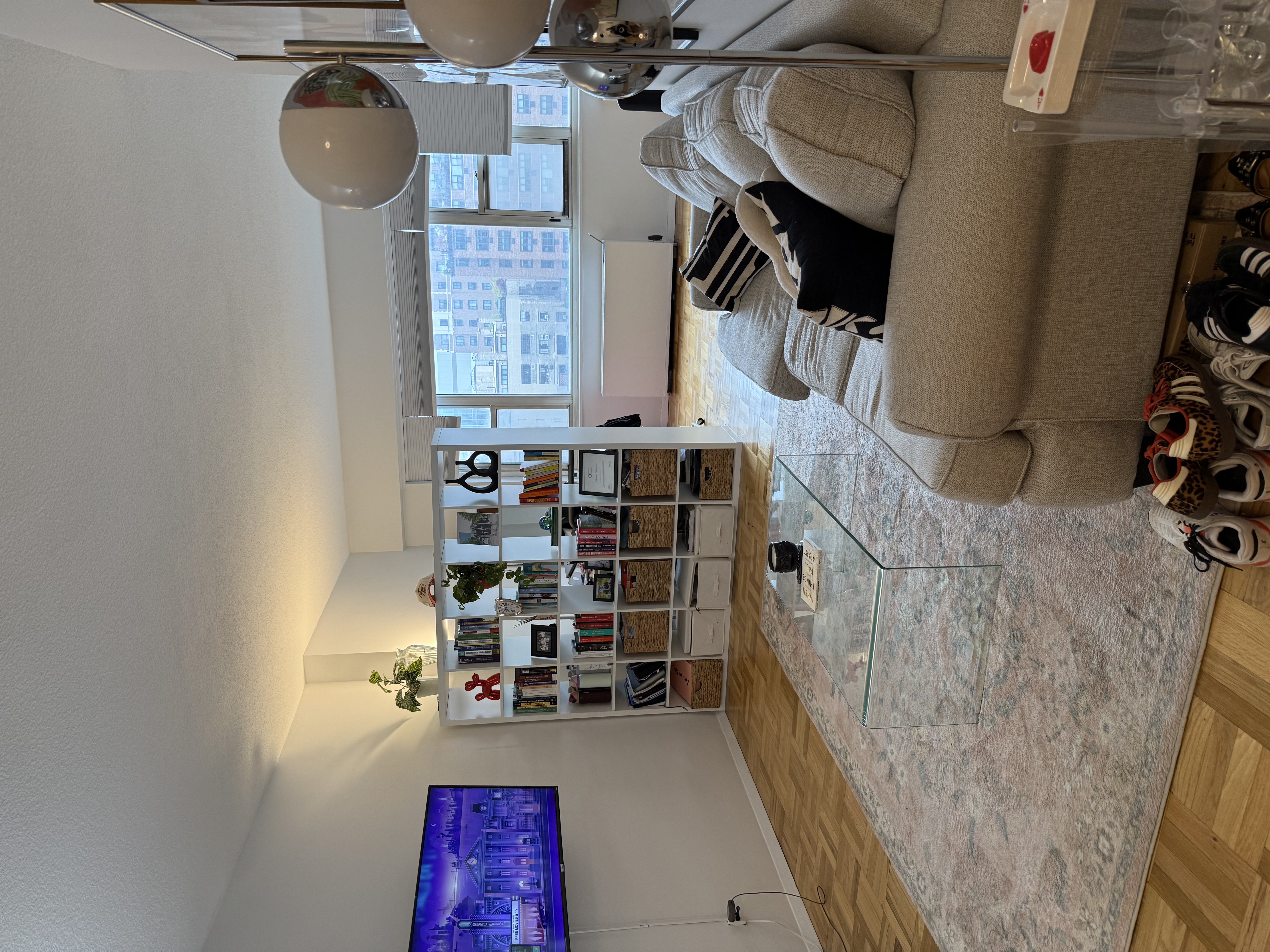 60 East 8th Street, Unit 9J Manhattan, NY 10003 - Photo 9 of 13 a living room with furniture and a large window